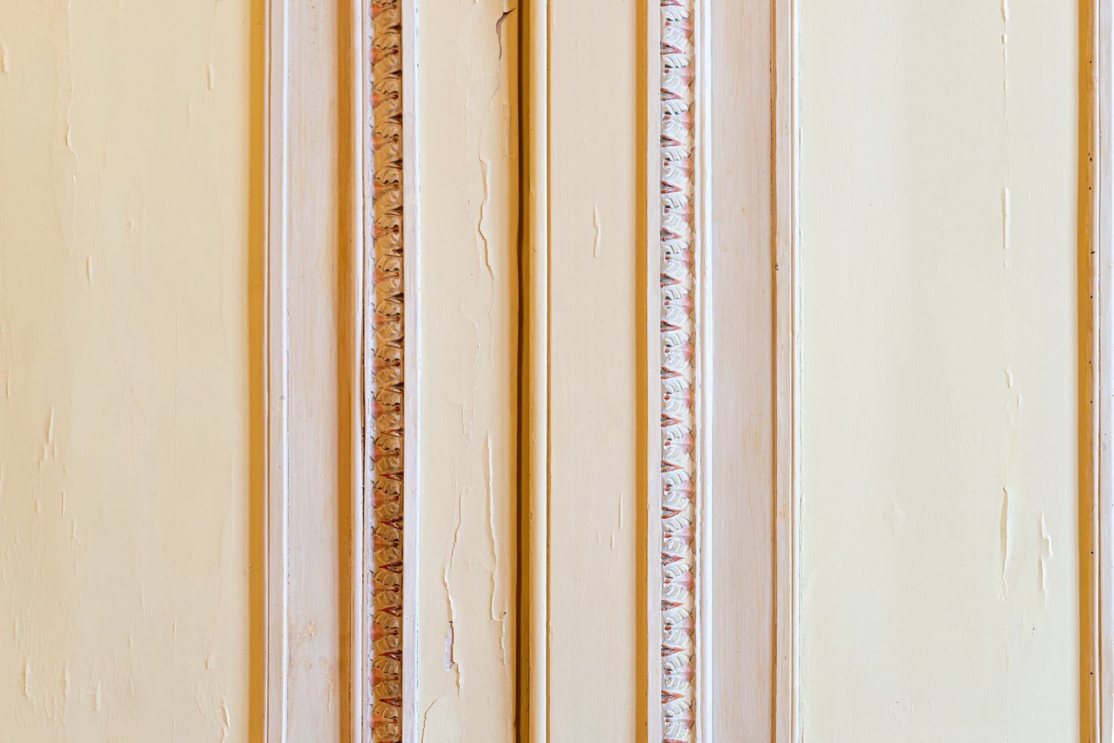 Detalle de molduras clásicas pintadas en tonos crema y oro