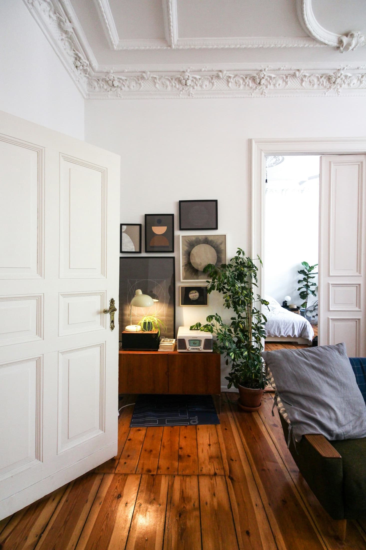 Salón de un piso clásico con techos moldurados, puertas dobles y suelo de madera